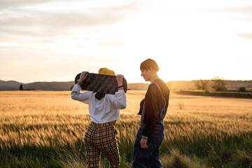 Fashion Lifestyle, Young couple happy with skateboard, backlit at sunset