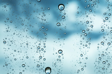 Naklejka na ściany i meble Rain on the window, natural skin of the rain The natural form of rainwater on a sky background.