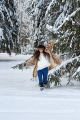 Girl runs through the snow in the woods.Caucasian girl