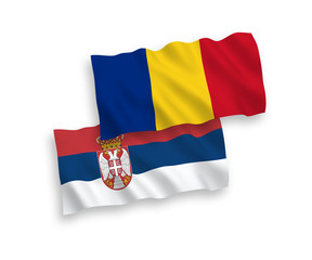 National vector fabric wave flags of Romania and Serbia isolated on white background. 1 to 2 proportion.