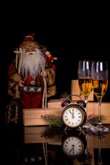 Two glasses with champagne, Santa Claus and christmas gifts