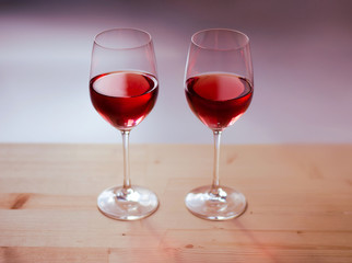 Two glasses of wine on a wooden table. Beautiful bright colors.