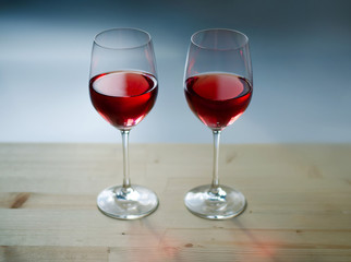 Two glasses of wine on a wooden table. Beautiful bright colors.