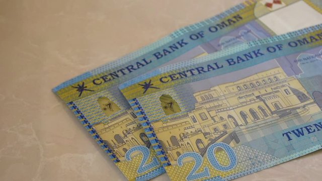 20 Riyal bills of cash, the currency of the Oman notes spread out on a semi white background.. Money exchange.