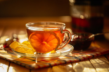 Cup of tea with lemon on a saucer with marmalade
