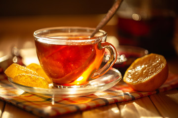 Cup of tea with lemon on a saucer with marmalade