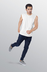 Fototapeta na wymiar Running fitness young guy model wearing white plain sports sleeveless shirt in dark blue denim jeans pant. Isolated background
