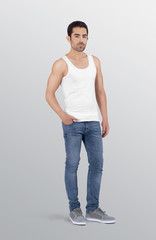 Side profile of young healthy male model wearing white plain white tank top shirt in blue denim jeans pant. Isolated background