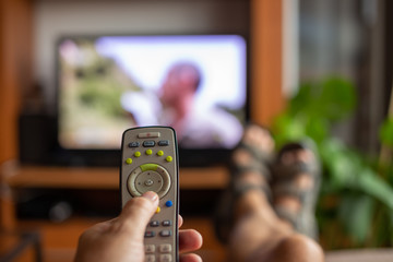 young man controlling the smart TV with a remote