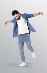 Standing male model spreading his arms wearing white plain white v neck t shirt and blue denim shirt upper in blue denim jeans pant. isolated background