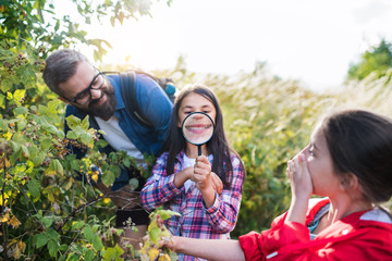 School children with teacher on field trip in nature, learning science.