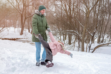 Fototapeta na wymiar Dad and little daughter are having fun outdoor in winter. Family concept.