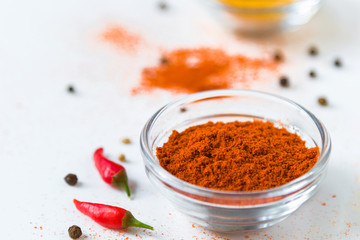 paprika in white bowl and colorful spices on a white background