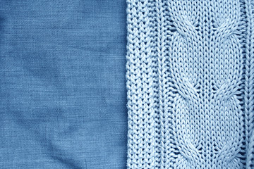 Blue knitted plaid and linen sheet. Close-up photo top view. Home background.