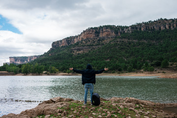 Adventurer with his backpack in a lake of Spain