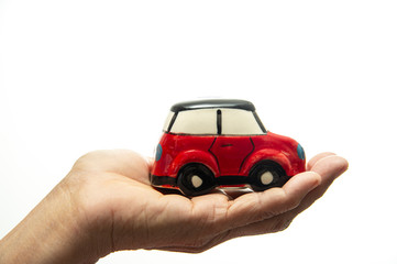 Hand holding red car isolated on white background.