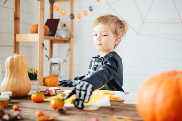 Halloween party. Little boy in a skeleton costume is ready to celebrate Halloween. Boy in a halloween dress-up room.