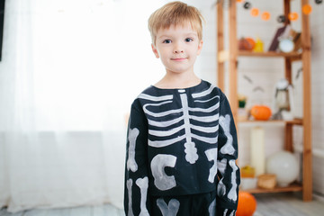 Holiday halloween. Funny little boy in a skeleton costume is ready to celebrate Halloween. Boy in a...