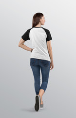Back view of  beautiful female model wearing white and black plain raglan t shirt in blue denim jeans capri pant. Isolated background.