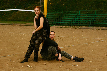 Two girls in military clothes and black t-shirts. Portrait. Patriotism. Army ammunition.