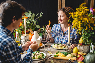 Holiday weekend date with wine and pasta. Cute dinner with flowers for a couple in love in romantic autumn atmosphere.