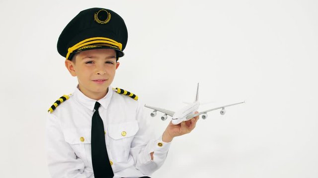 Boy wearing pilot's uniform holds scale airliner moder