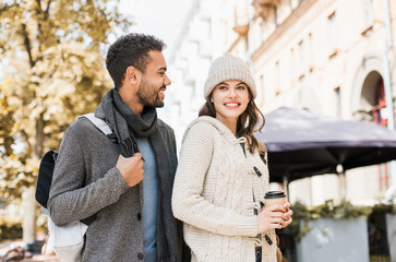 Beautiful happy couple autumn portrait. Young joyful smiling woman and man in a city in winter. Love, travel, tourism, students concept