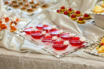 Raspberry Jello with fresh fruits on a festive table