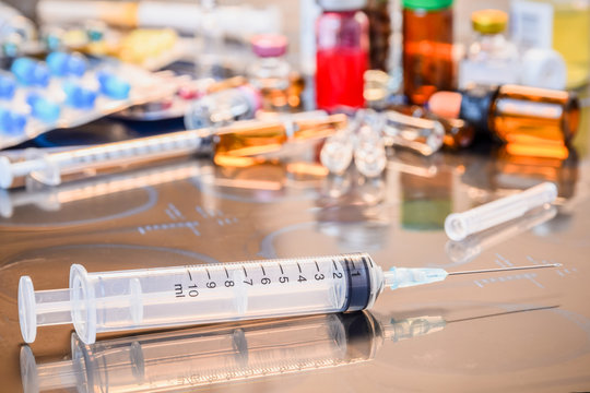 Glass Medicine Vials ampule ,medicine pill and capsule Syringe on x-ray film over doctor table for background shallow DOF