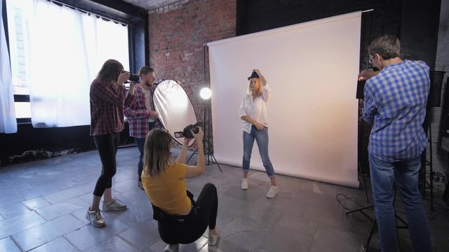 photo workshop, a company of creative photographers takes pictures of a young model during training in studio shooting