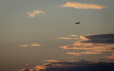 A plane flying to a holiday destination over a sunset