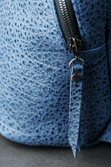 Blue backpack made of genuine leather on a dark background, handmade.