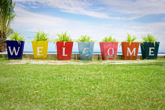 Welcome written on a colorful blocks at tropical beach, sea , sky green, resort image