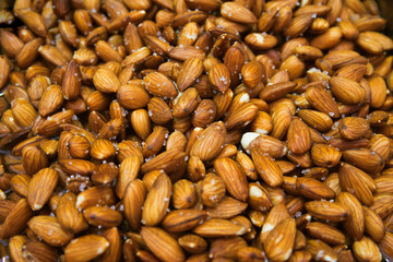 Peeled almond nuts with salt at the market close up