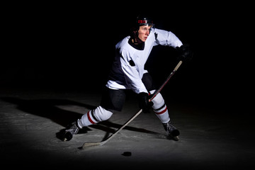 ice hockey player in action kicking with stick