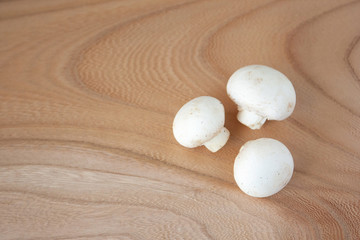 木のまな板の上の白いマッシュルーム