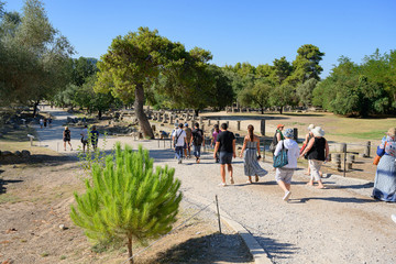 Touristen gehen auf das Gelände des antiken Olympia, Peleponnes, Griechenland