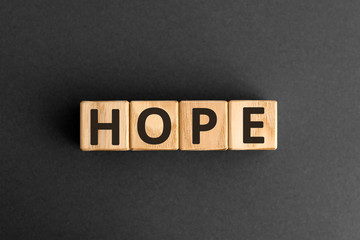 Obraz premium Hope - word from wooden blocks with letters, a feeling of trust hope concept, top view on grey background