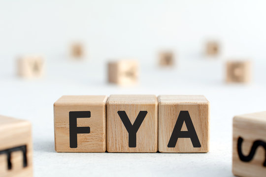 FYA - word from wooden blocks with letters, For Your Attention, for for your amusement, abbreviation FYA concept,  white background