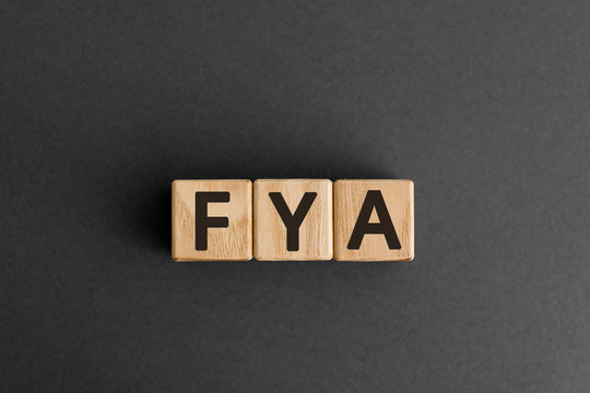 FYA - word from wooden blocks with letters, For Your Attention, for for your amusement, abbreviation FYA concept,  white background