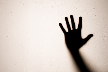 Arm Silhouette on glass, Scary hand beating on frosted glass. copy space
