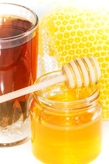 Honey on the background of honeycomb. Honey in a glass jar and honeycomb