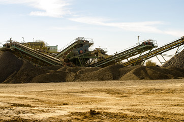 Fototapeta premium Mobile Stone crusher machine by the construction site or mining quarry for crushing old concrete slabs into gravel and subsequent cement production