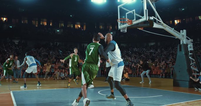 Basketball players on big professional arena during the game. Tense moment of the game. Celebration