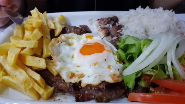 Dipping a french frie in the yolk of a fried egg