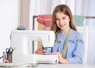 Teenager girl working with sewing machine as a tailor