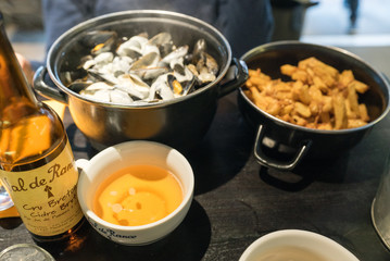 delicious traditional mussels with roquefort cheese and french fries dish and local apple cider close up view