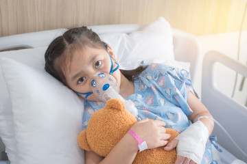 Patient Girl use inhalation with Nebulizer mask at hospital's bed