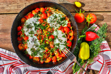 fried eggs with vegetables in a pan