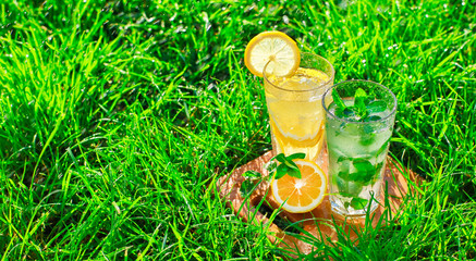 lemonade in a glass on green grass